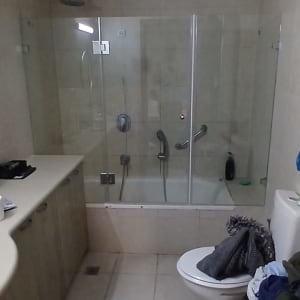 חדר אמבטיה עם מקלחון זכוכית ואביזרי רחצה