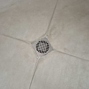 ניקוז מים ברצפת מקלחת עם ריצוף אפור