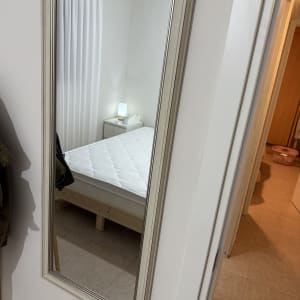 מראה על קיר עם חדר שינה ברקע