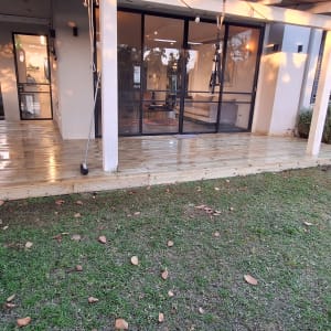 דק עץ חדש עם שולחן בחצר בית