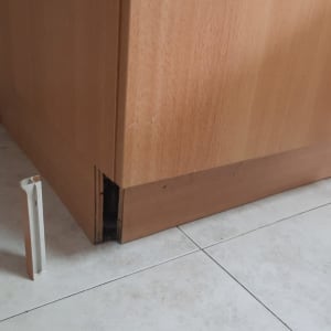 ארון מטבח עם פאנל תחתון חסר על רצפה לבנה