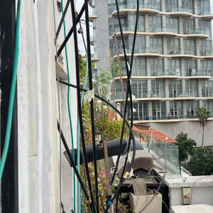 צינורות שחורים וירוקים מחוברים לקיר חיצוני