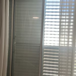 חלון עם וילונות לבנים בחדר מואר