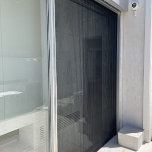 תריסים שחורים על דלת זכוכית במרפסת חיצונית