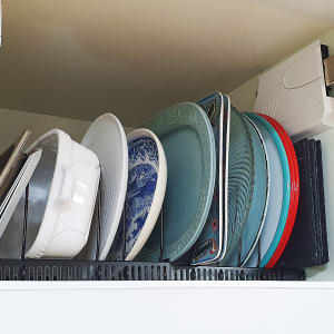 צלחות מסודרות בארון מטבח על מתקן ייבוש