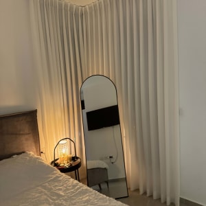 וילון לבן ארוך תלוי בפינת החדר