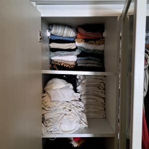 ארון בגדים עם בגדים מקופלים ומסודרים על מדפים