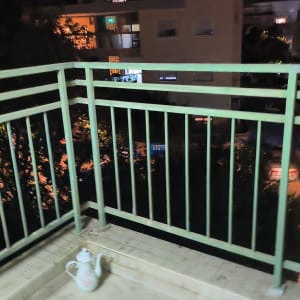 מעקה מתכת ירוק של מרפסת לאחר צביעה