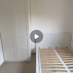 מיטה עם מסגרת עץ וארון לבן בחדר ריק