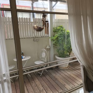 חלון זכוכית גדול עם וילון לבן בצד ימין