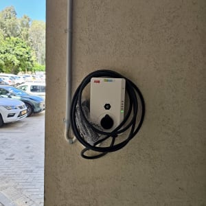 מטען חשמלי עם כבל תלוי על קיר חיצוני