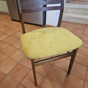 כיסא עם מושב מרופד בצבע צהוב על רצפת אריחים
