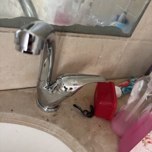 ברז כרום מותקן על משטח שיש לצד כיור רחצה