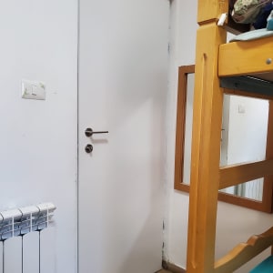 דלת לבנה עם ידית מתכת בחדר שינה