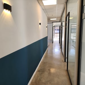 קיר צבוע בחצי לבן וחצי כחול במסדרון מואר