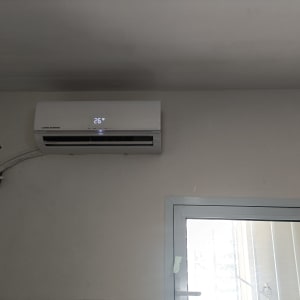 מזגן מותקן על קיר עם תצוגת טמפרטורה 26 מעלות