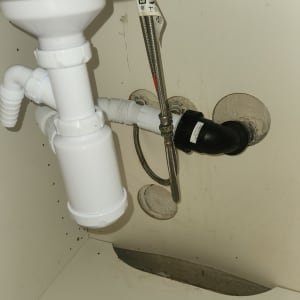 צנרת מתחת לכיור עם חיבורים ואביזרים