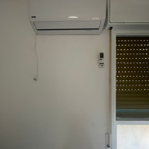 מזגן מותקן על קיר עם שלט רחוק לידו