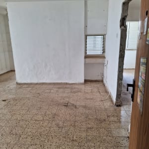 חדר ריק עם קירות לבנים ורצפת אריחים