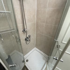 מקלחון עם דלתות זכוכית וברז מתכת