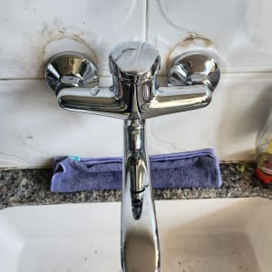 ברז כרום מעל כיור עם כתמי חלודה