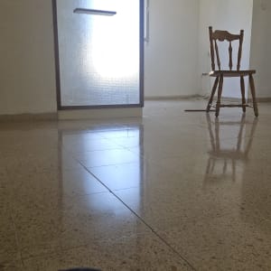 רצפה מבריקה עם כיסא ומטאטא בחדר ריק