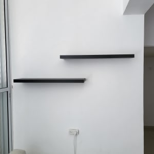 שתי מדפים שחורים מותקנים על קיר לבן