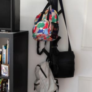 מתלה קיר שחור עם תיקים תלויים עליו