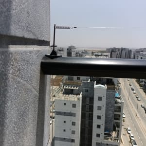 חוט מתכת עם קפיץ למניעת יונים על מעקה מרפסת