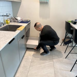 אדם מתקין ארון במטבח עם כלים