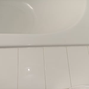 חיבור בין אמבטיה לרצפת אריחים לבנים