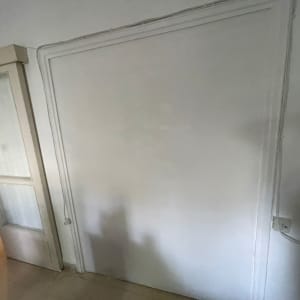 קיר גבס עם דלת פתוחה ושקע חשמל