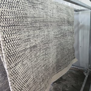 שטיח תלוי לייבוש על מתקן מתכת