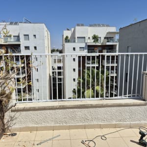 מרפסת עם מעקה מתכת וכלי עבודה