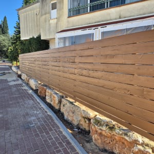 גדר עץ חומה ליד שביל מרוצף