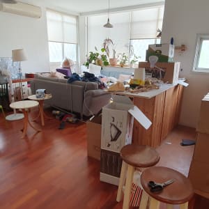 חדר עם קופסאות קרטון, רהיטים וכלי בית מפוזרים