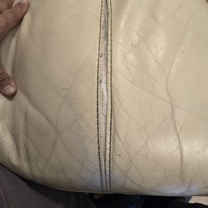 תפר קרוע בכרית עור עם כלי עבודה ליד