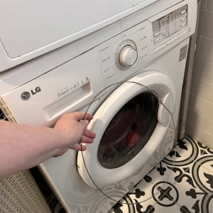 מכונת כביסה עם יד מחזיקה חוט מתכת