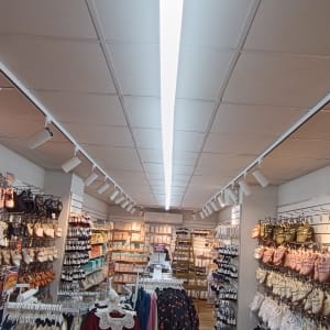 תאורת תקרה בחנות בגדים עם מדפים ותלייה