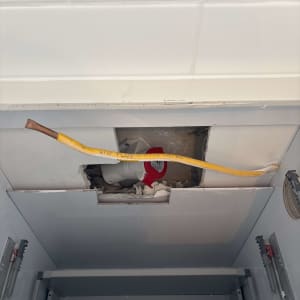 חוט חשמל צהוב יוצא מתקרה עם חור