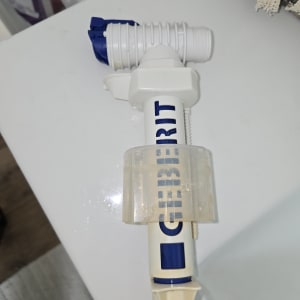 חלק פלסטיק לבן עם כיתוב כחול, כנראה חלק אינסטלציה