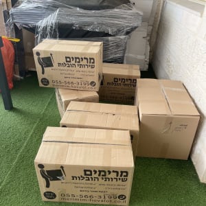 ארגזים עם לוגו של חברת הובלות על דשא מלאכותי