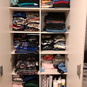 ארון בגדים מסודר עם בגדים מקופלים ומוצרי טיפוח