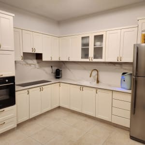 מטבח מודרני עם ארונות לבנים וברז זהב