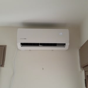 מזגן מותקן על קיר בחדר עם חלון