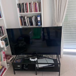 טלוויזיה על שולחן עם שלט משחק וחוטים