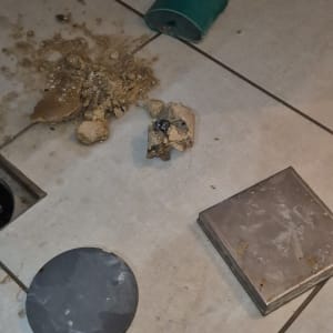 צינור ירוק שבור על רצפה עם לכלוך