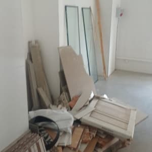ערימת חומרים וכלים בחדר ריק עם קירות לבנים