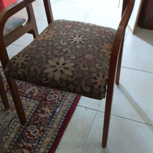 כיסא עץ עם ריפוד פרחוני על שטיח