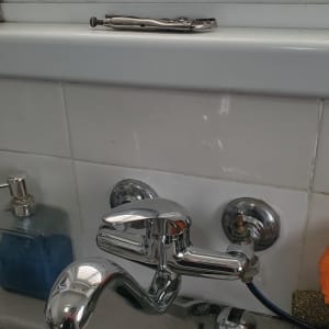 ברז כרום עם כלי עבודה על אדן החלון